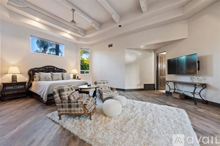 A bedroom with a bed, chair, and a television.