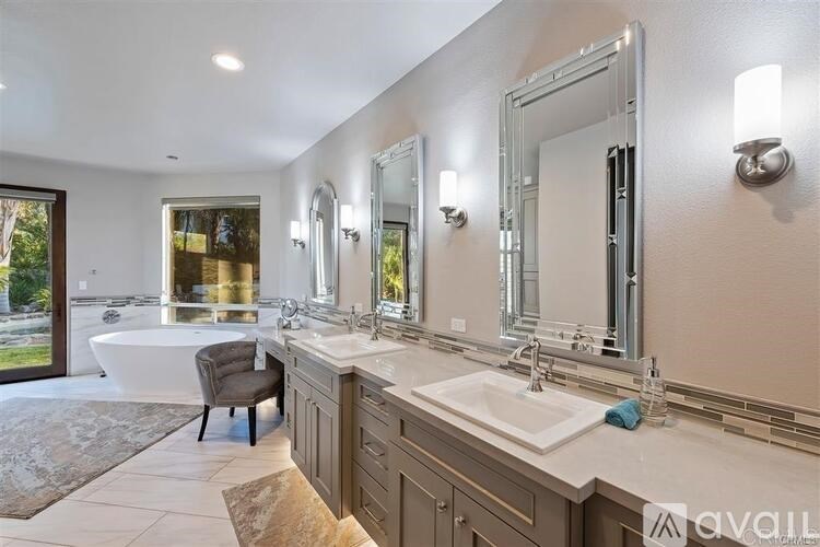 A bathroom with a tub, sink, and mirror.