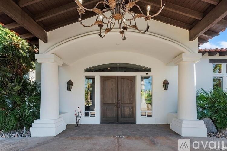 A house entrance with a wooden door and a chandelier.