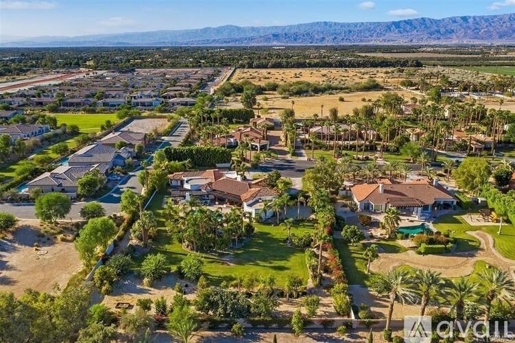 A bird's eye view of a residential neighborhood with houses and palm trees.