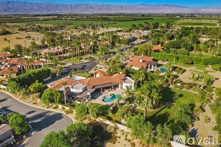A bird's eye view of a neighborhood with a large house in the center.