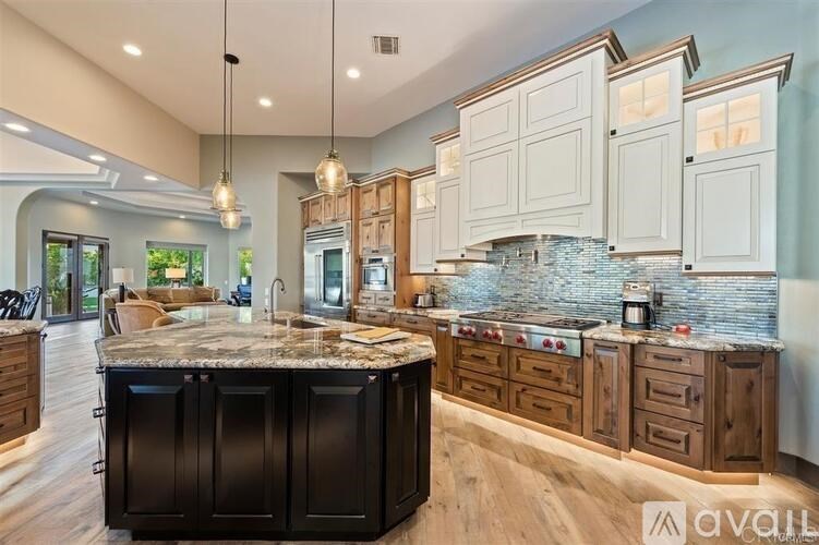 A kitchen with a marble island and wooden cabinets.