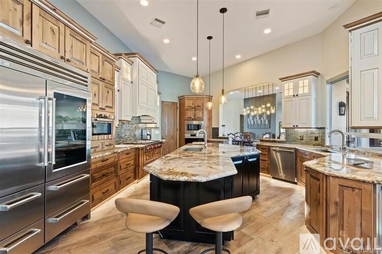 A modern kitchen with a center island and stainless steel appliances.