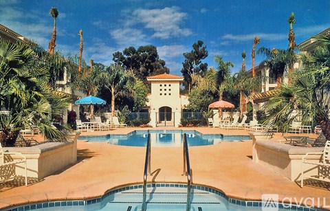 A pool surrounded by palm trees and chairs.