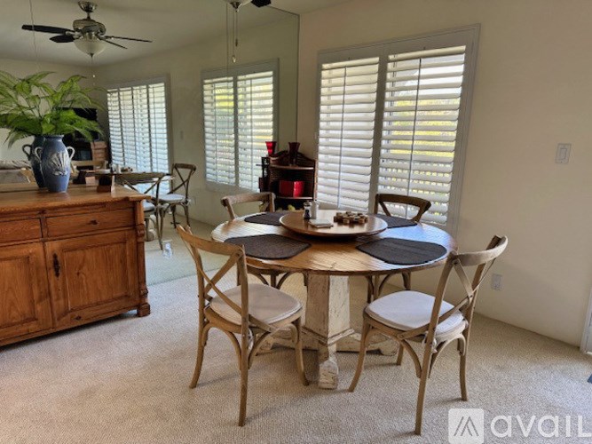 A dining room with a round table and chairs.