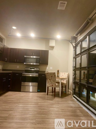 A kitchen with dark wood cabinets and a dining table with chairs.