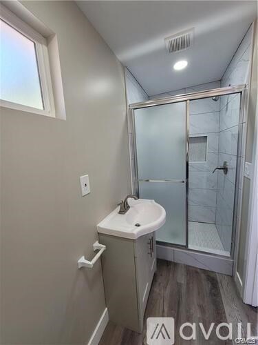 A bathroom with a sink, mirror, and lights.