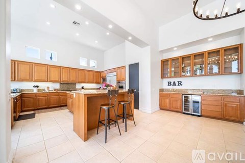 A kitchen with wooden cabinets and a bar area.
