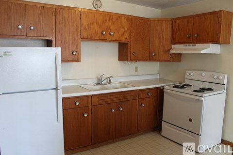 A kitchen with wooden cabinets and a white refrigerator.