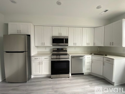 A modern kitchen with white cabinets and stainless steel appliances.