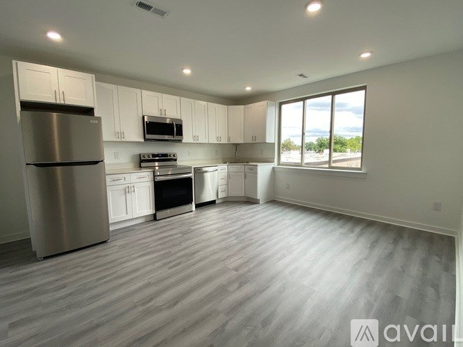 A spacious kitchen with stainless steel appliances and white cabinets.