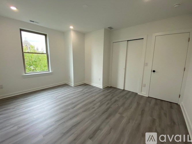 A room with a window and wooden flooring is available for rent.