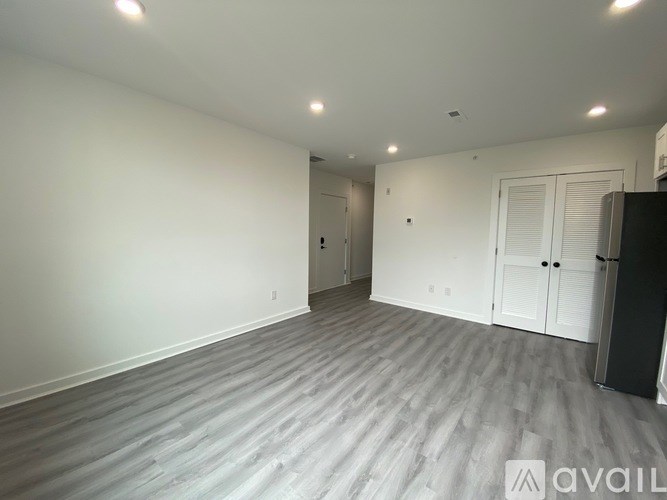 A spacious room with a grey floor and white walls.