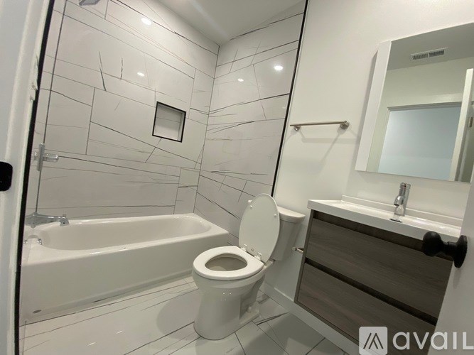 A bathroom with a toilet, sink, and bathtub.