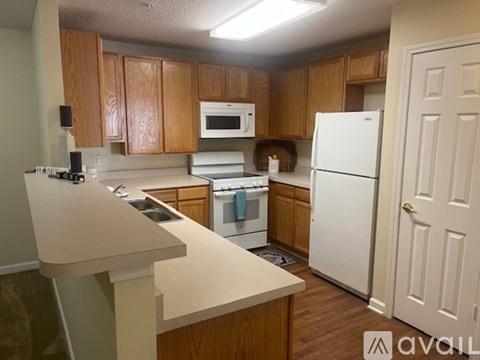 A kitchen with wooden cabinets and white appliances.