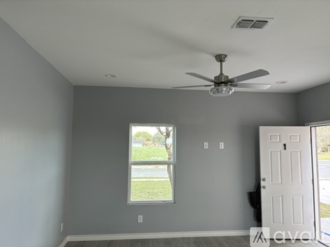 A room with a ceiling fan and a window.