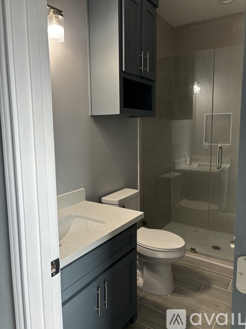 A bathroom with a toilet, sink, and shower.