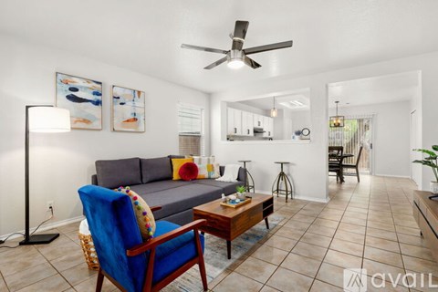 A living room with a blue chair and a grey couch.