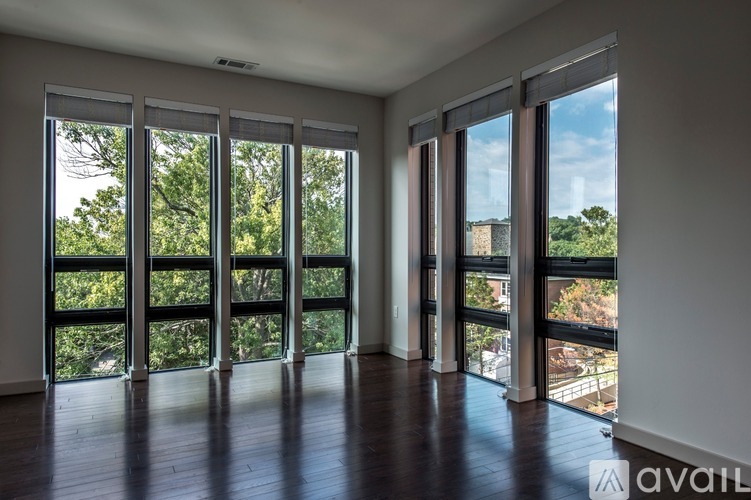 A room with large windows and wooden floors.