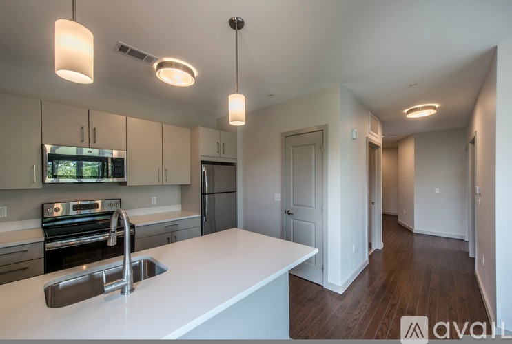 A kitchen with white countertops and a sink.