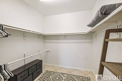 A bedroom with a bunk bed and a dresser with clothes hanging on it.