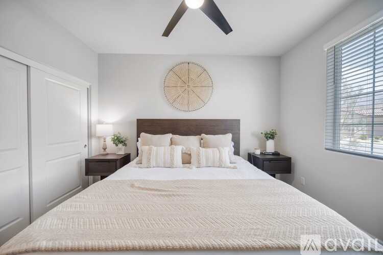 A bedroom with a large bed and a ceiling fan.