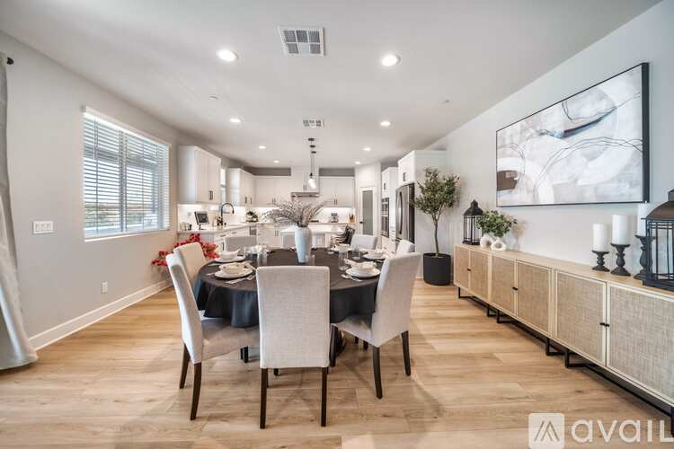 A modern dining room with a large table set for six.
