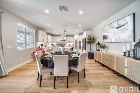 A modern dining room with a large table set for six.