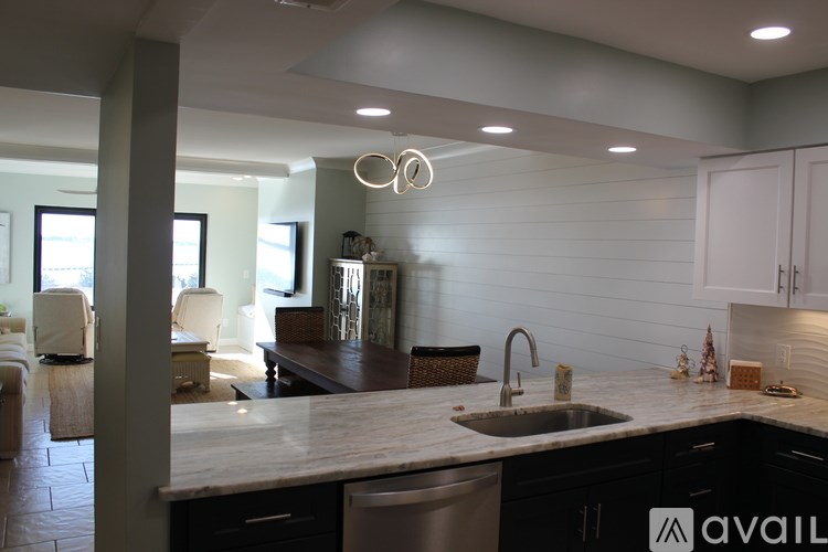 A kitchen with a marble countertop and a sink.