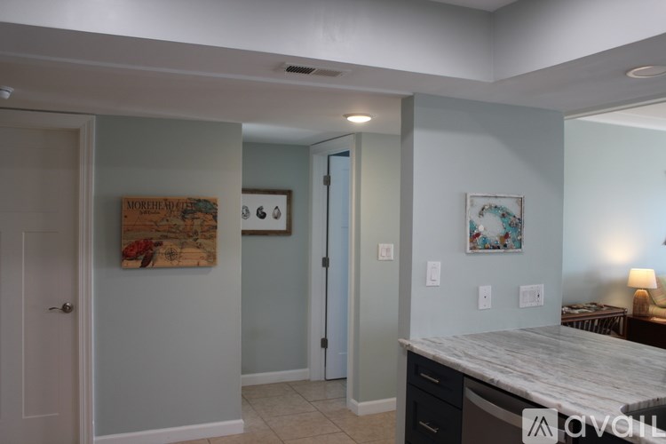 A kitchen with a marble countertop and a painting on the wall.