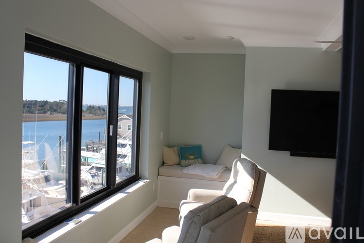 A living room with a large window overlooking a marina.
