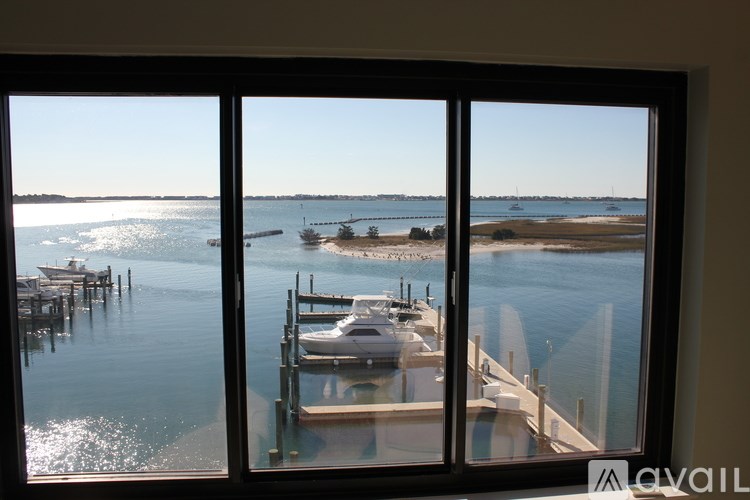 A view from a window looking out to a body of water with boats docked at a pier.