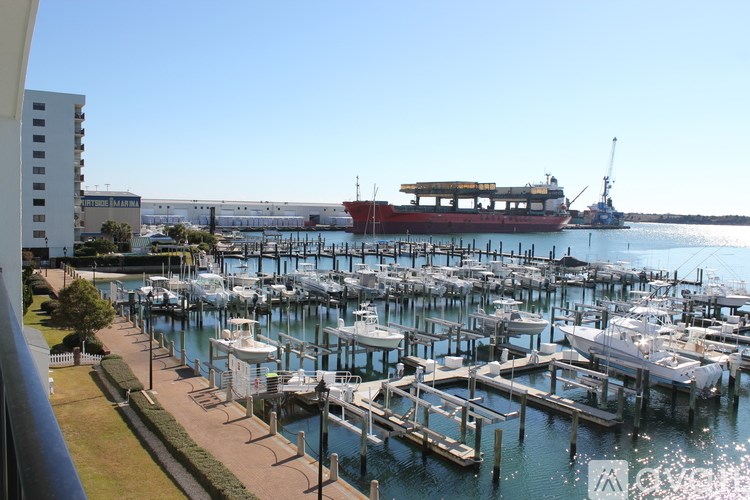 A marina with boats docked and a crane in the background.