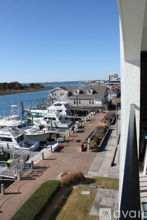A marina with boats docked and a building in the background.