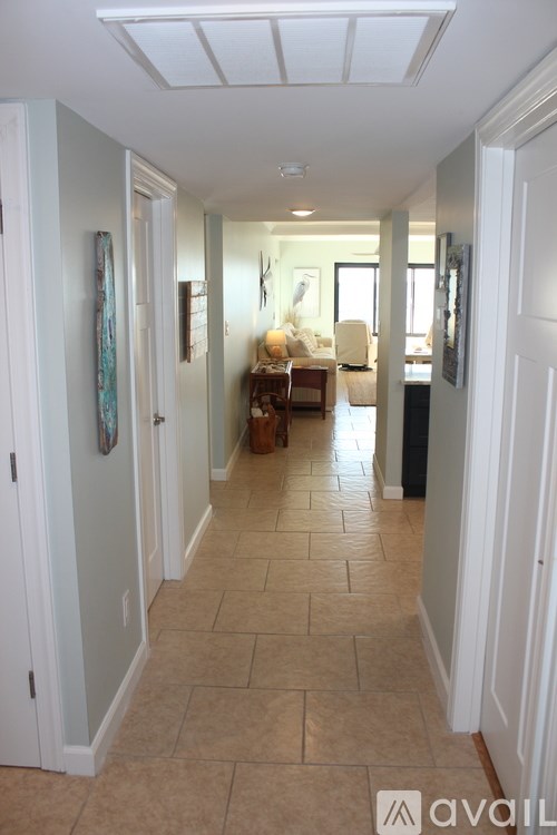 A hallway with tiled floors and white walls.