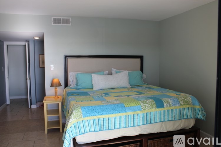 A bedroom with a bed, nightstand, and lamp.