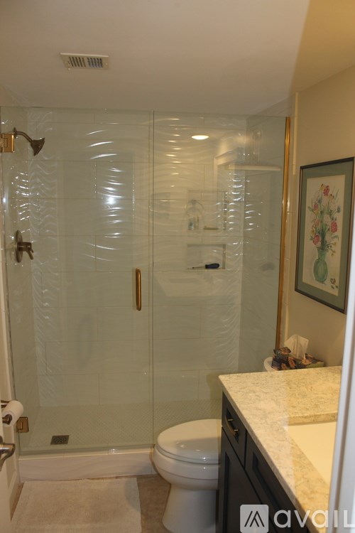 A bathroom with a toilet, sink, and shower.