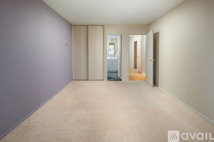 A hallway with a carpeted floor and a door on the right.