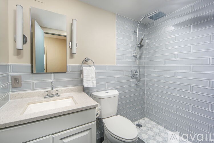 A bathroom with a toilet, sink, and mirror.