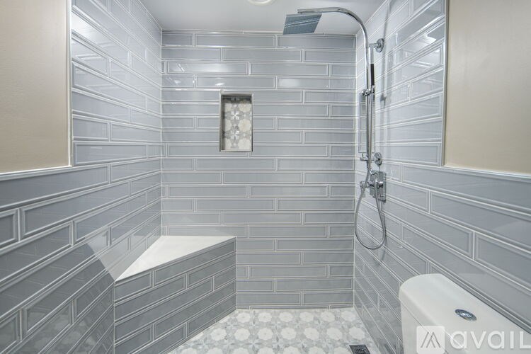 A bathroom with a shower and a white tub.