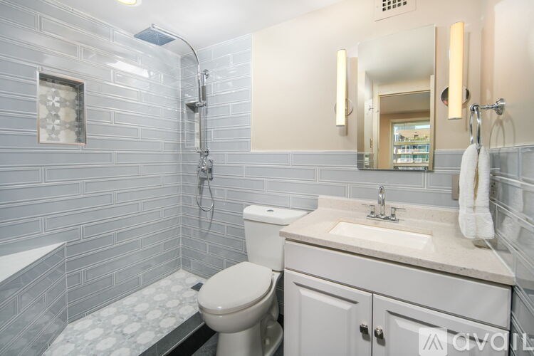 A bathroom with a toilet, sink, and a mirror.