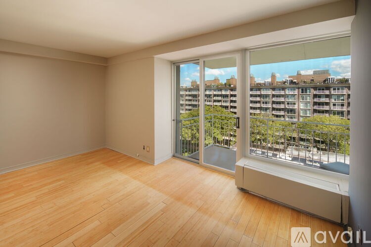 A room with wooden flooring and a window overlooking a cityscape.