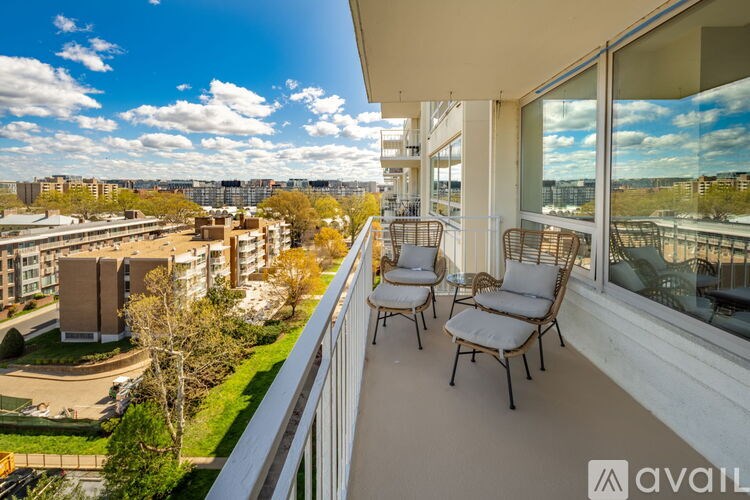 A balcony with chairs and a view of a cityscape.