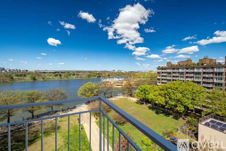 A balcony overlooks a river and a cityscape.