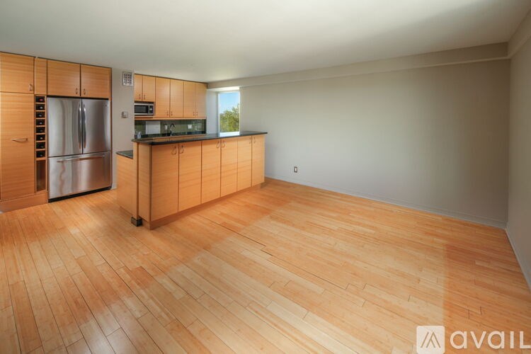 A kitchen with wooden cabinets and a refrigerator.