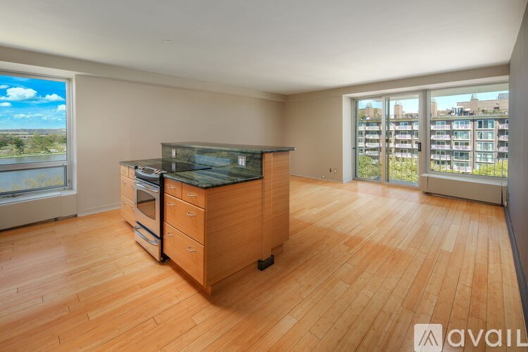 A kitchen with wooden floors and a large window overlooking a cityscape.