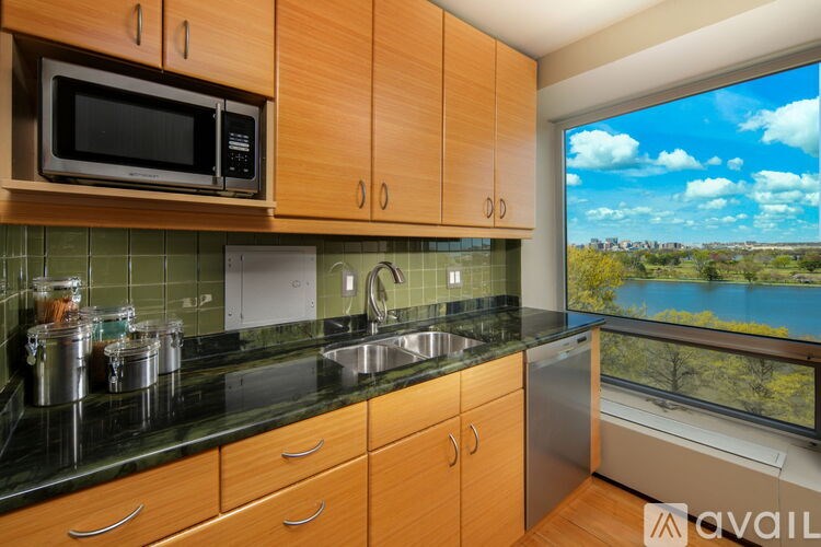 A kitchen with wooden cabinets and a view of a lake.