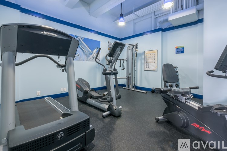 A gym with treadmills, elliptical machines, and other exercise equipment.