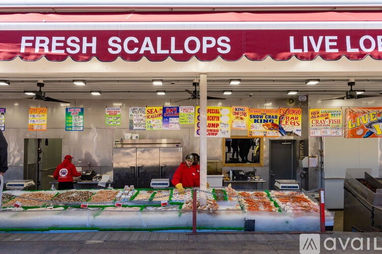 A seafood stand with a sign that says Fresh Scallops Live On.