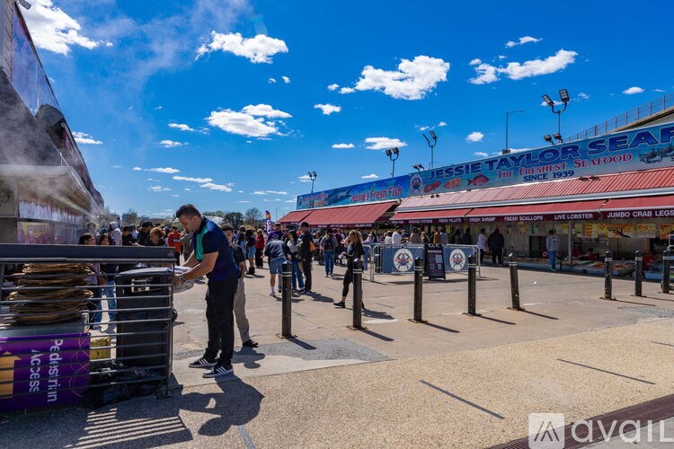 A man is standing in front of a stack of pizza boxes at an outdoor event.